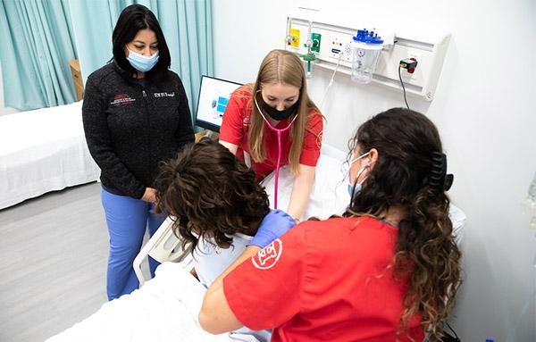 nursing students in simulation lab with manikin